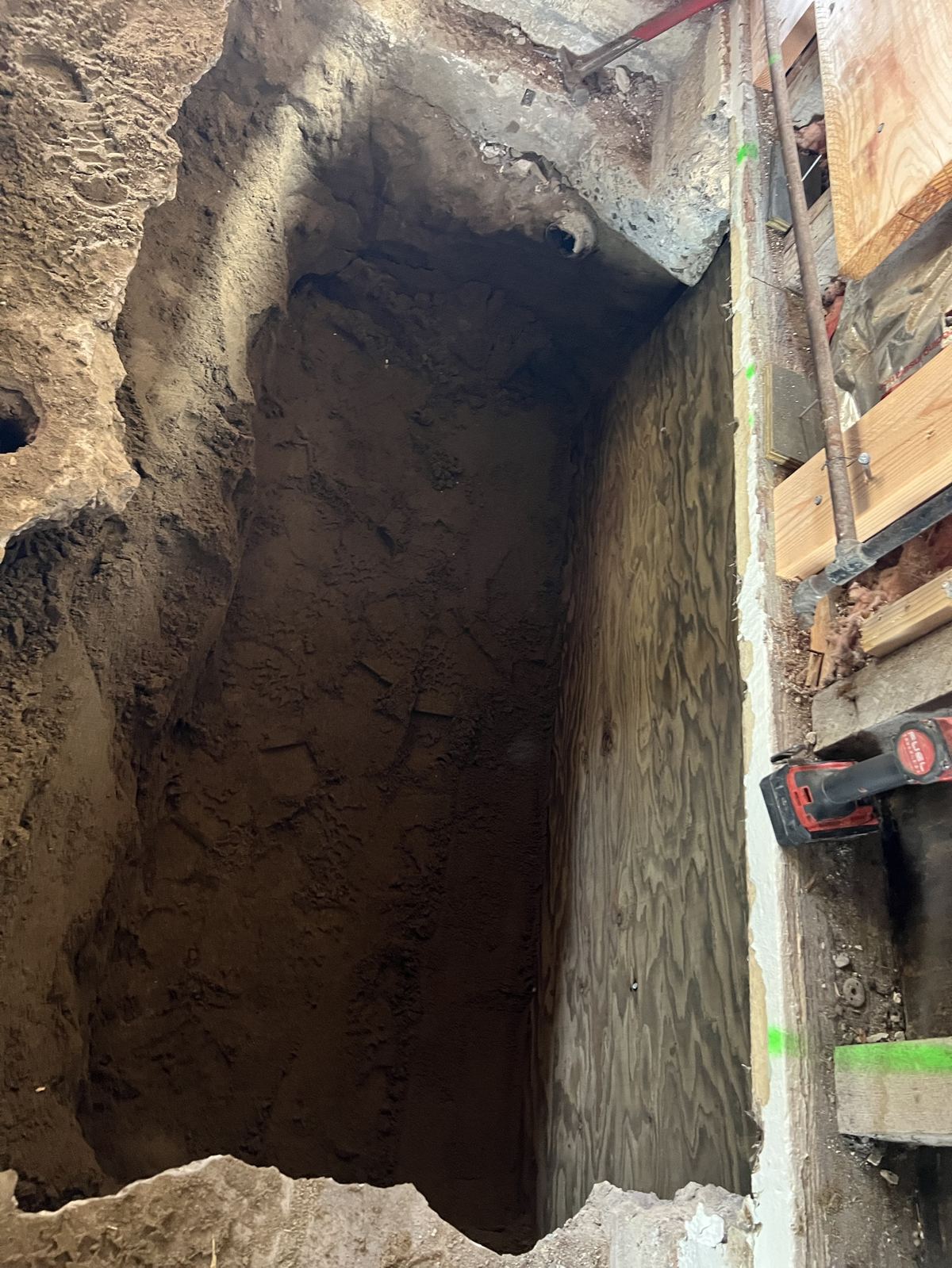 New foundation stem wall formed with plywood along excavated trench