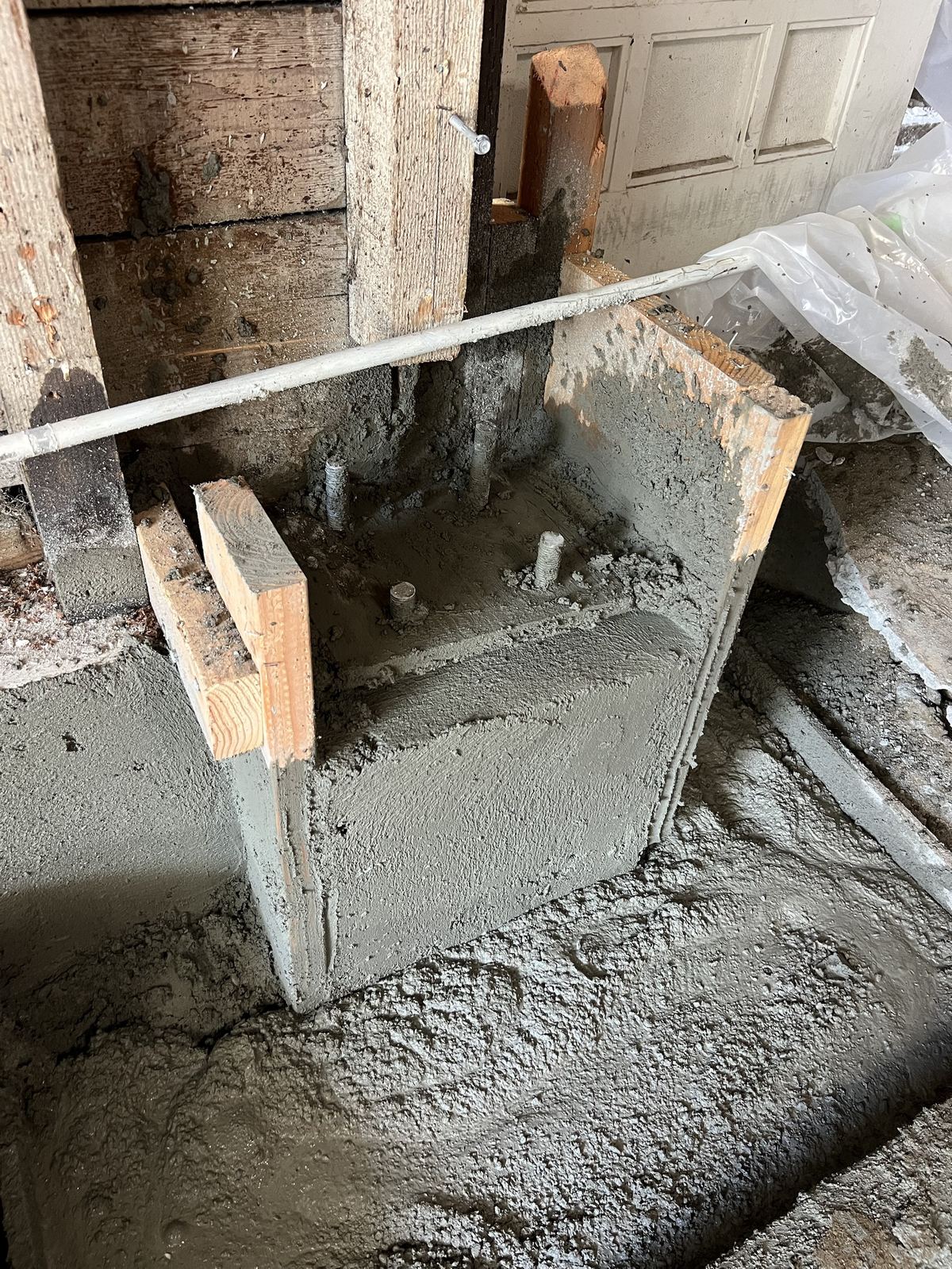 New concrete pier footing with anchor bolts set for structural framing